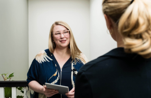 Image of a consultant talking to another woman in a hallway about infertility