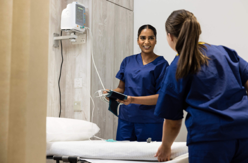 Two female nurses in scrubs discussing HyCoSy and treament